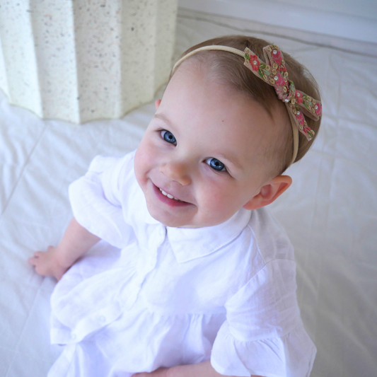 Pearl Pink Hair Bow, an embellished pink bow with pearls for babies and girls, featuring a soft headband for infants and secure clips for older girls.