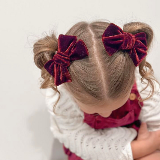 Girl wearing the Red Velvet Pigtail Set, featuring two classic bows as right and left clips, each measuring 8.5 cm wide and 6 cm tall. Crafted from luxurious red velvet, these festive accessories add charm to her hairstyle, perfect for holiday celebrations and everyday wear.